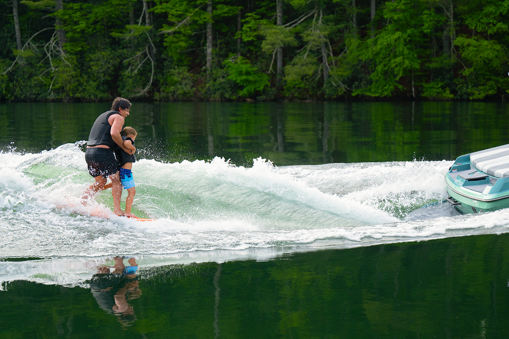 Axis wakeboat accelerates across the water, generating a clean, shaped wake for wakeboarding and surfing.