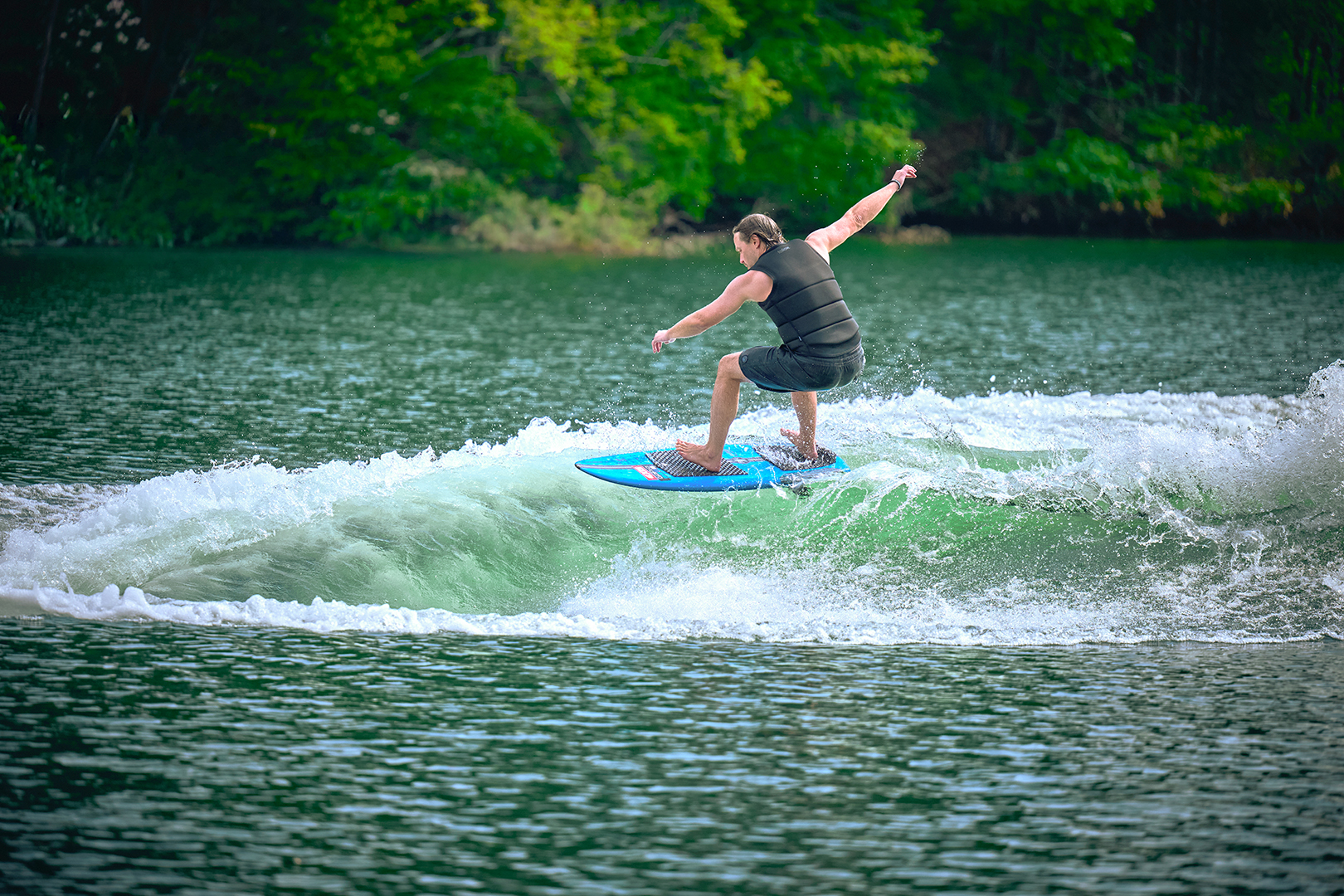 Wakeboarder performs an inverted trick behind an Axis wakeboat, highlighting the boat’s consistent and rampy wake.