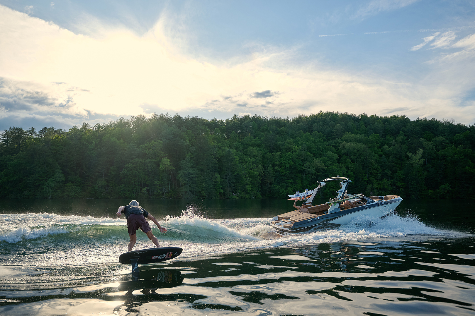 Rider cuts hard behind the Malibu 21 LX while another boat approaches from behind.