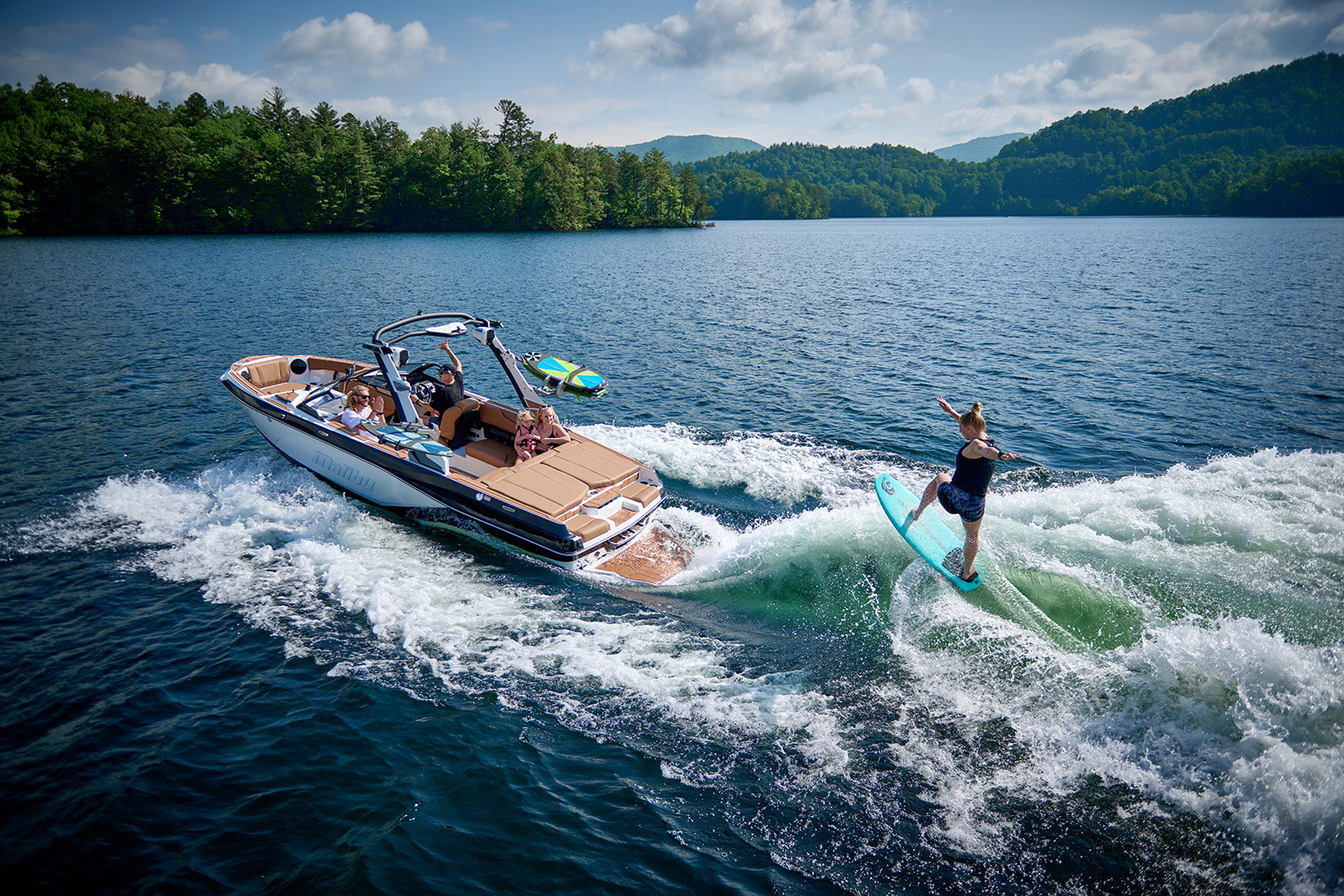 Malibu 21 LX creates a wave behind the boat as a rider drops in.