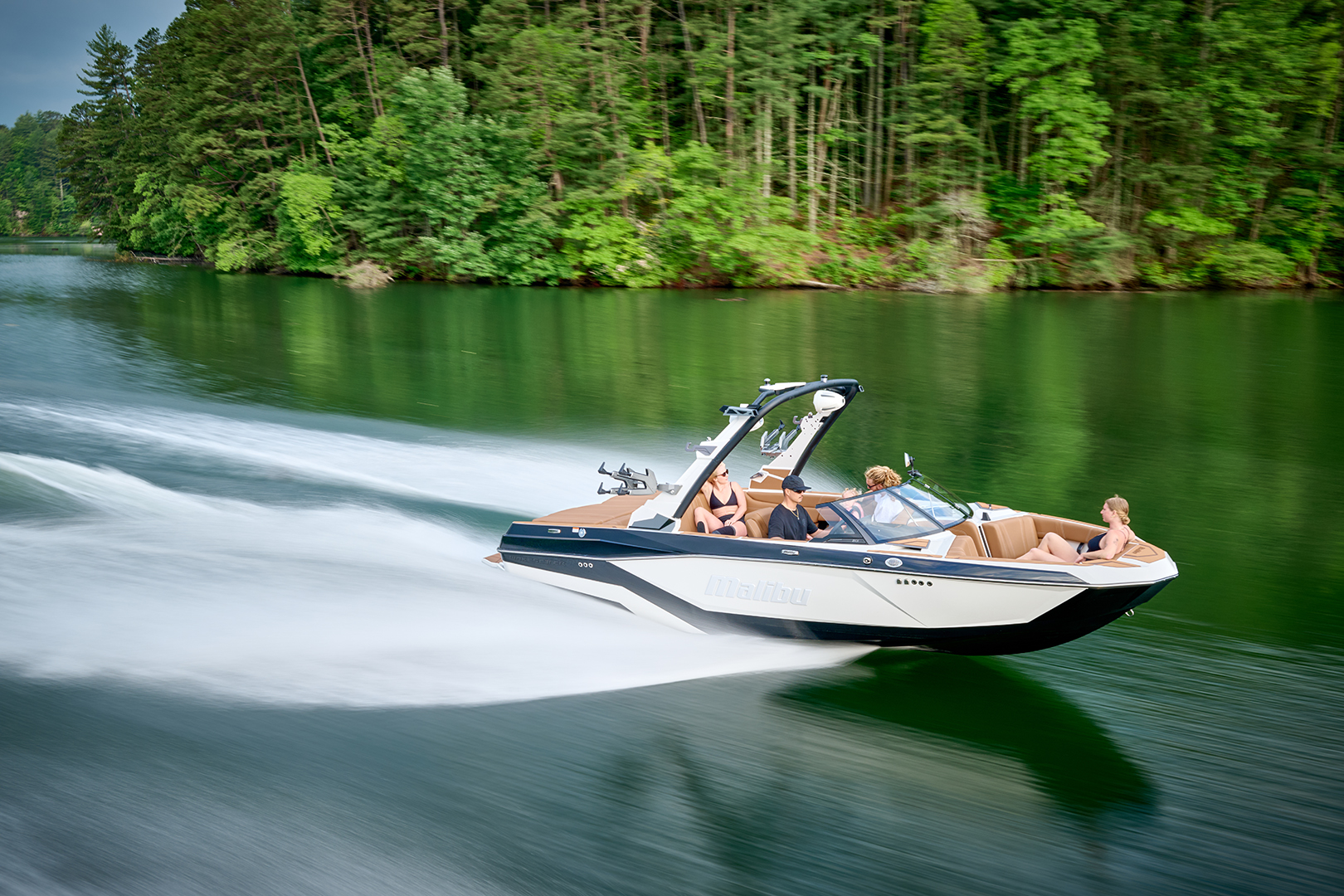 Side profile of the Malibu 21 LX cruising at speed, showing hull design and tower.