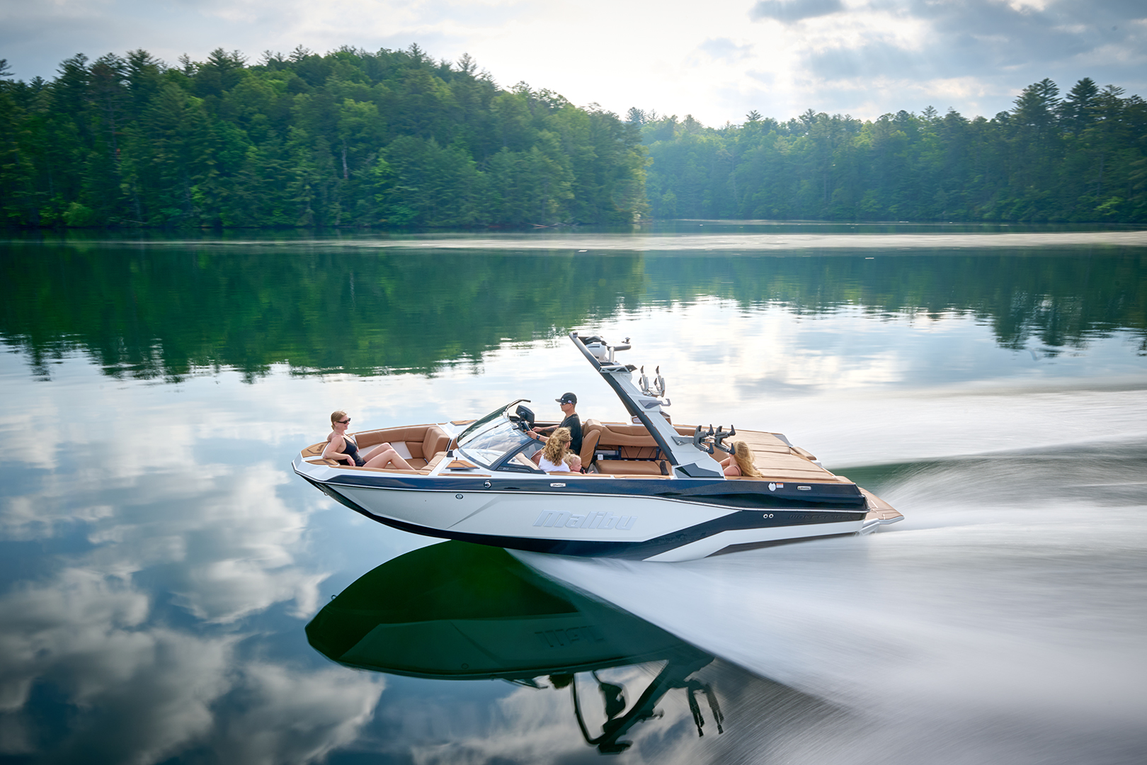 Malibu 21 LX underway with passengers, showing full interior and rear storage.