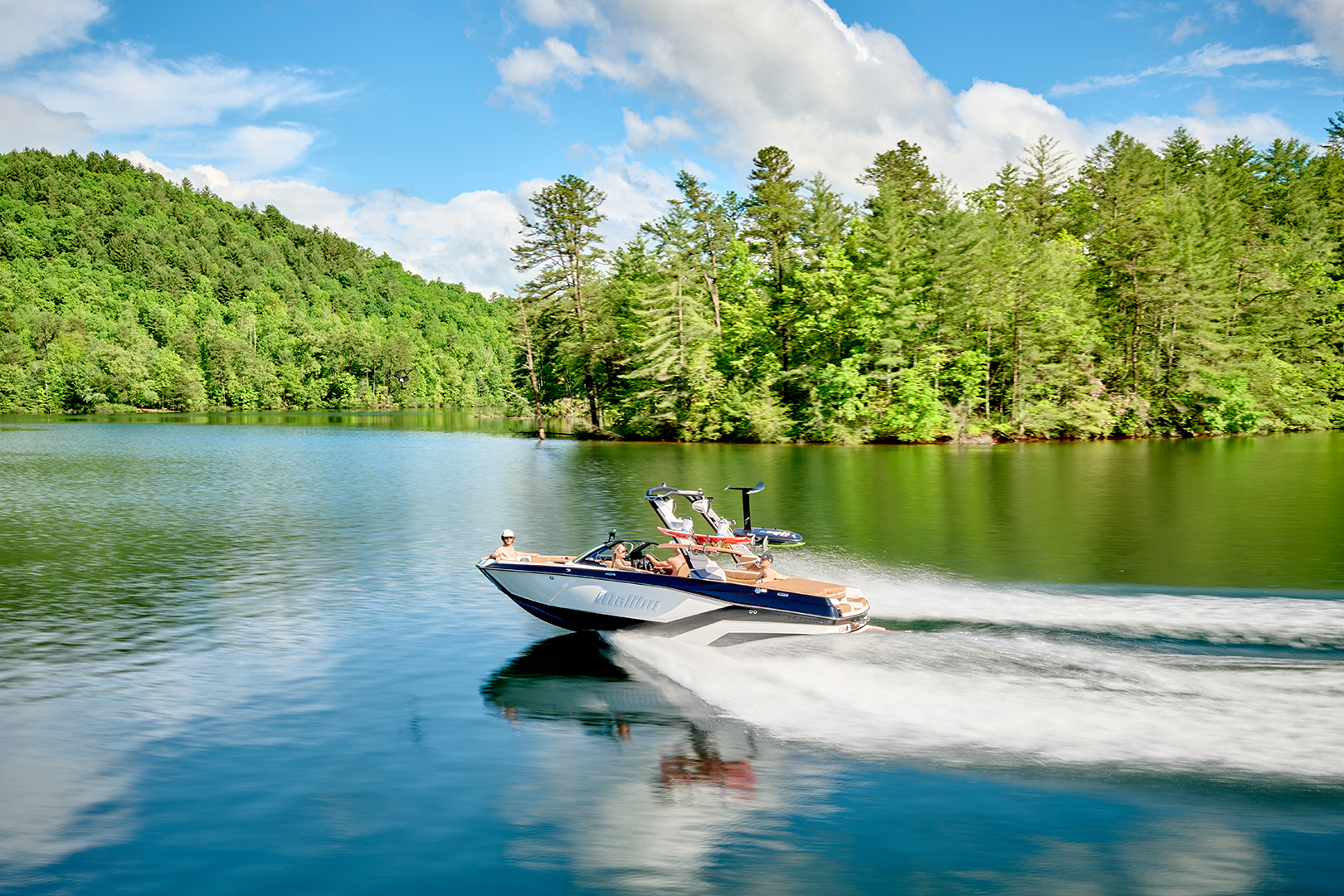 The Malibu 21 LX powers through the lake, showing wake formation and clean lines.